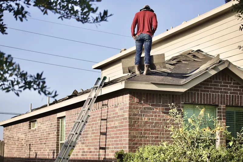 Professional roofer working on a residential roof in Swanton